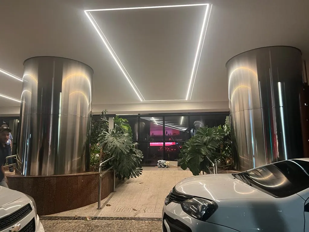 Colunas revestidas em aço inox polido em hall corporativo